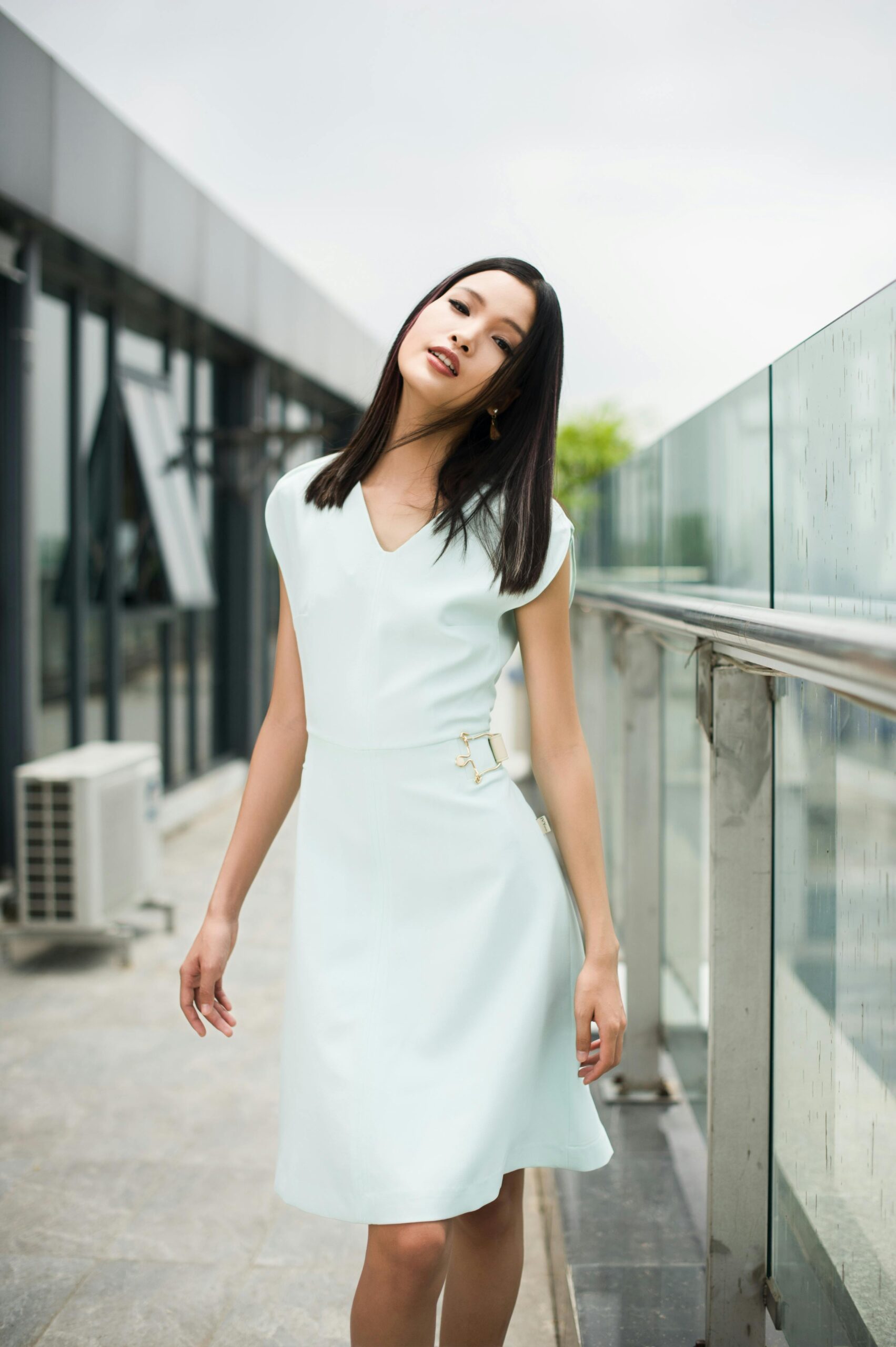 A fashionable woman in a white dress poses outdoors in Hà Nội, Vietnam.
